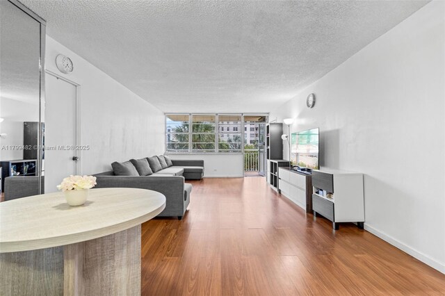 251 174th St Unit 212, Sunny Isles Beach, FL 33160 - living area with a textured ceiling, wood finished floors, and baseboards