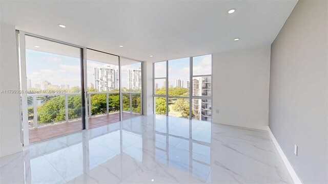 3625 N Country Club Dr Unit 609, Aventura, FL 33180 - spare room with marble tiled floors, a city view, baseboards, floor to ceiling windows, and recessed lighting