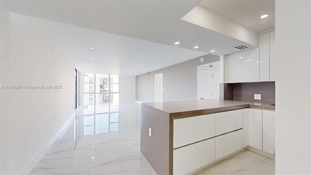 3625 N Country Club Dr Unit 609, Aventura, FL 33180 - kitchen with modern cabinets, light marble finish floors, white cabinetry, recessed lighting, and a peninsula