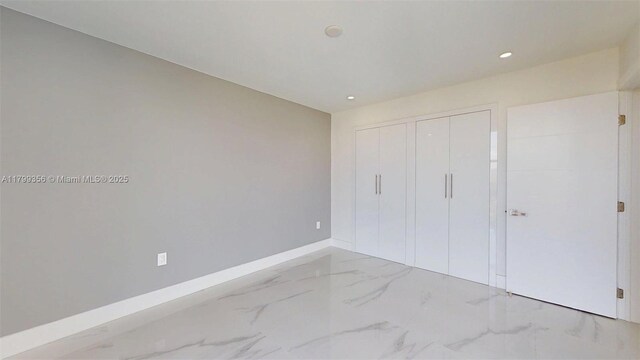 3625 N Country Club Dr Unit 609, Aventura, FL 33180 - unfurnished bedroom with marble finish floors, a closet, baseboards, and recessed lighting