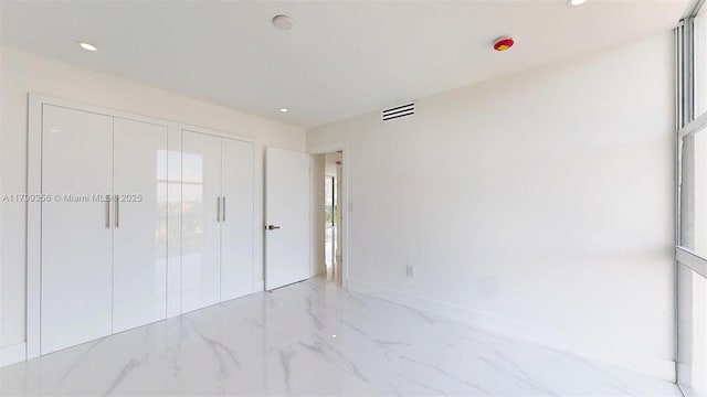 3625 N Country Club Dr Unit 609, Aventura, FL 33180 - unfurnished bedroom with light marble finish floors, recessed lighting, a closet, multiple windows, and baseboards