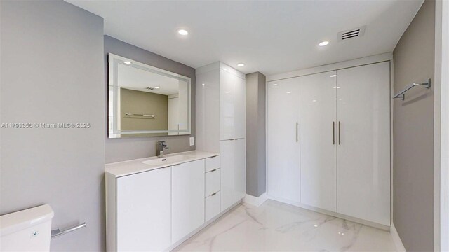 3625 N Country Club Dr Unit 609, Aventura, FL 33180 - bathroom with marble look tiles, toilet, vanity, recessed lighting, and baseboards