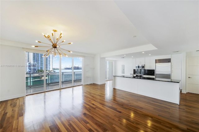 901 Brickell Key Blvd Unit 607, Miami, FL 33131 - unfurnished living room with a chandelier, dark wood-type flooring, baseboards, recessed lighting, and a water view