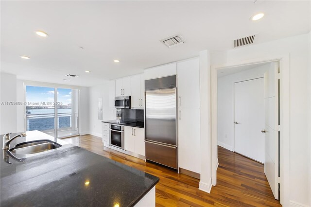 901 Brickell Key Blvd Unit 607, Miami, FL 33131 - kitchen with appliances with stainless steel finishes, a sink, wood finished floors, white cabinets, and recessed lighting