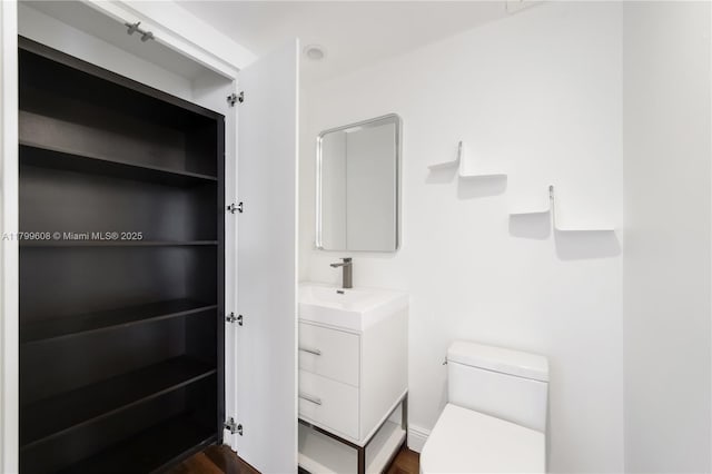 901 Brickell Key Blvd Unit 607, Miami, FL 33131 - bathroom featuring toilet, vanity, and wood finished floors