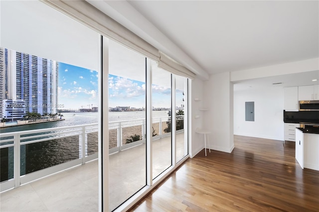901 Brickell Key Blvd Unit 607, Miami, FL 33131 - interior space with a water view, electric panel, light wood-style flooring, baseboards, and a wall of windows