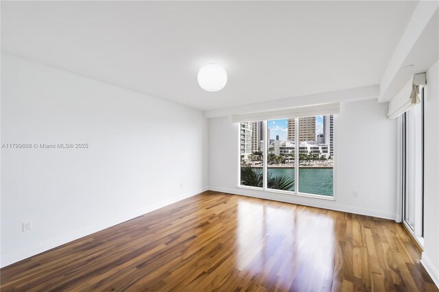 901 Brickell Key Blvd Unit 607, Miami, FL 33131 - spare room featuring wood finished floors, baseboards, and a view of city
