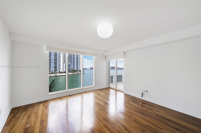 901 Brickell Key Blvd Unit 607, Miami, FL 33131 - unfurnished room featuring wood finished floors, baseboards, and a water view
