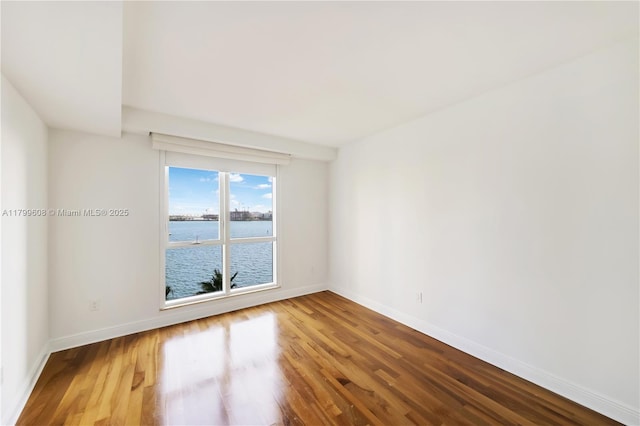 901 Brickell Key Blvd Unit 607, Miami, FL 33131 - unfurnished room with wood finished floors, baseboards, and a water view
