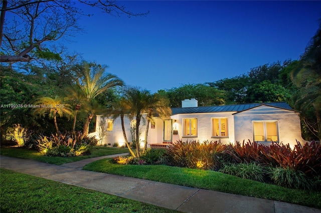 246 NE 92nd St, Miami Shores, FL 33138 - view of front facade with a standing seam roof, stucco siding, a chimney, and metal roof