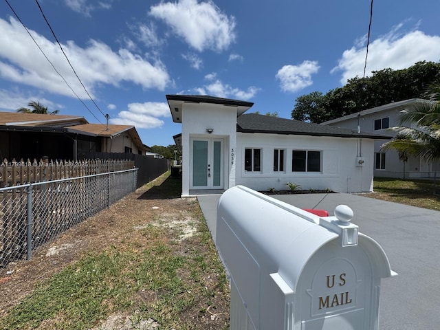 3039 NW 51st Ter, Miami, FL 33142 - view of front of house with french doors, fence, and stucco siding