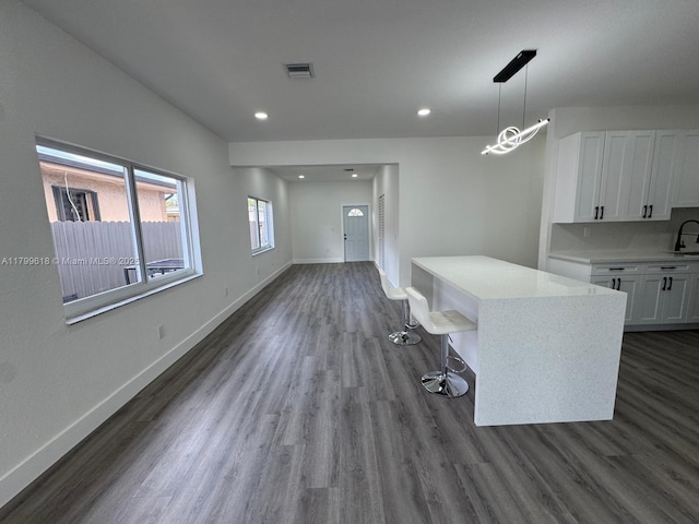 3039 NW 51st Ter, Miami, FL 33142 - kitchen with white cabinets, dark wood-style floors, baseboards, decorative light fixtures, and recessed lighting
