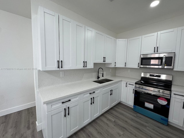3039 NW 51st Ter, Miami, FL 33142 - kitchen featuring stainless steel appliances, a sink, light countertops, white cabinetry, and dark wood-style floors