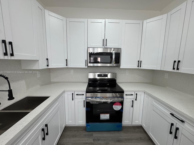 3039 NW 51st Ter, Miami, FL 33142 - kitchen featuring stainless steel appliances, a sink, dark wood-style flooring, and white cabinets