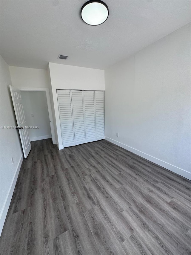 3039 NW 51st Ter, Miami, FL 33142 - unfurnished bedroom with dark wood-style flooring, baseboards, and a closet