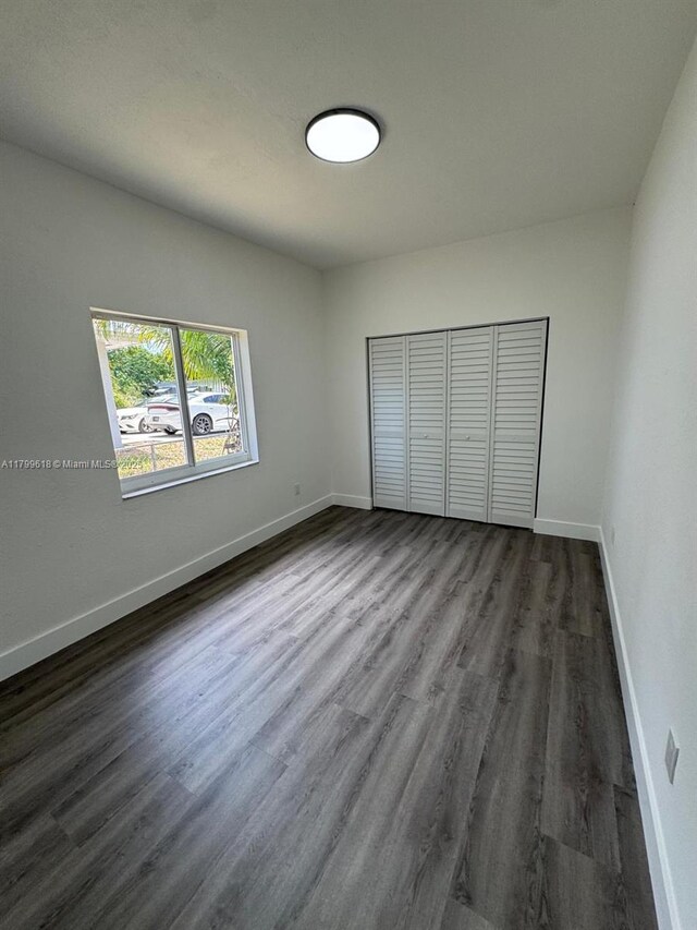 3039 NW 51st Ter, Miami, FL 33142 - unfurnished bedroom featuring dark wood-type flooring, a closet, and baseboards