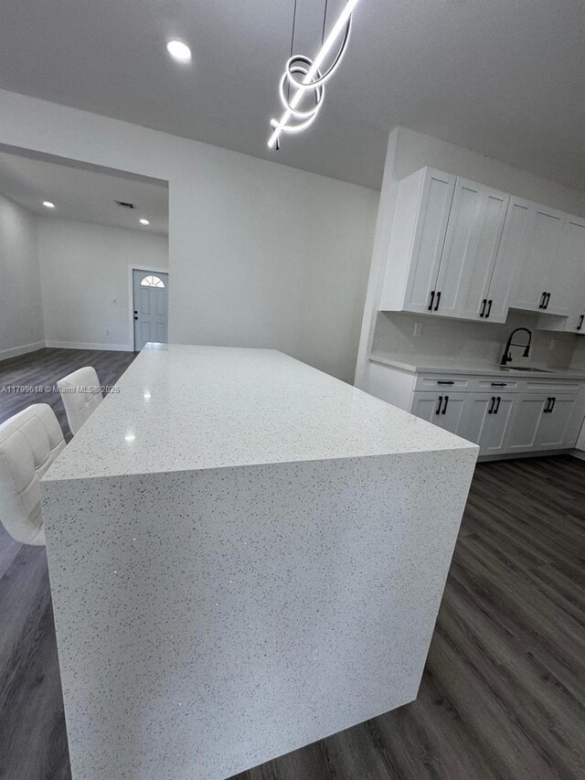 3039 NW 51st Ter, Miami, FL 33142 - kitchen featuring a kitchen island, white cabinets, dark wood-style floors, light stone countertops, and recessed lighting
