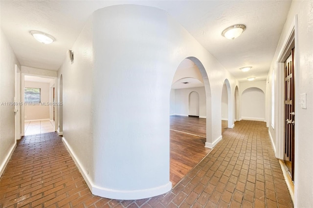 10840 NW 40th St, Coral Springs, FL 33065 - hall featuring brick flooring, baseboards, and arched walkways