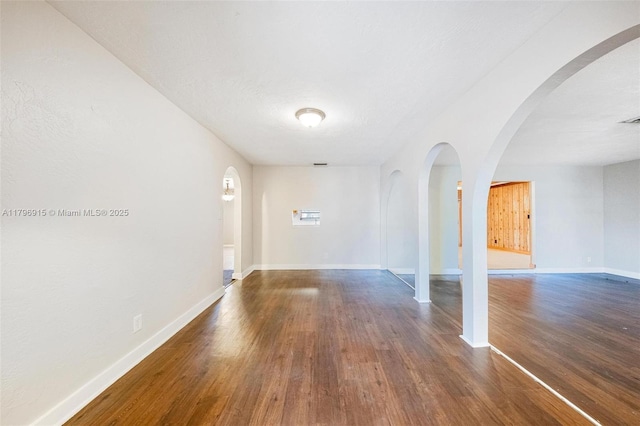 10840 NW 40th St, Coral Springs, FL 33065 - empty room featuring wood finished floors, arched walkways, and baseboards