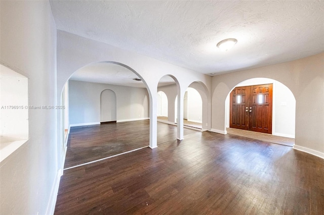 10840 NW 40th St, Coral Springs, FL 33065 - entryway featuring wood finished floors, arched walkways, baseboards, and a textured ceiling