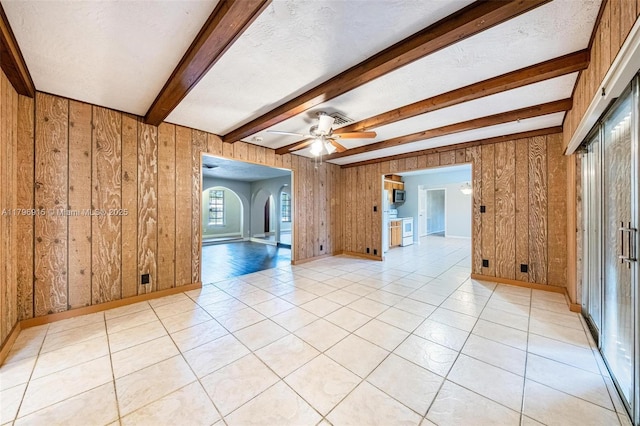 10840 NW 40th St, Coral Springs, FL 33065 - spare room featuring wooden walls, beam ceiling, ceiling fan, light tile patterned floors, and baseboards