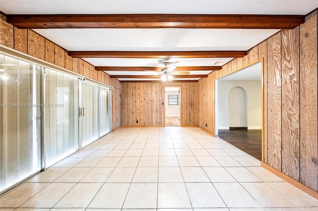 10840 NW 40th St, Coral Springs, FL 33065 - empty room with a ceiling fan, beamed ceiling, arched walkways, and wood walls