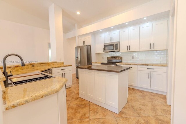 808 Hampton Ct, Weston, FL 33326 - kitchen with appliances with stainless steel finishes, a sink, tasteful backsplash, white cabinets, and a kitchen island