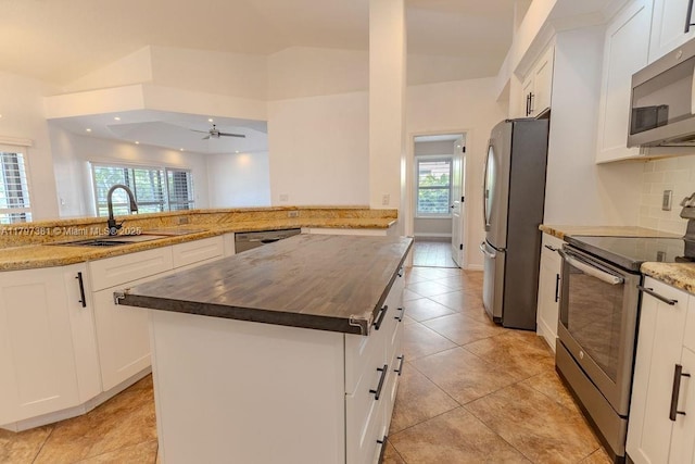 808 Hampton Ct, Weston, FL 33326 - kitchen with appliances with stainless steel finishes, a sink, a kitchen island, backsplash, and white cabinets