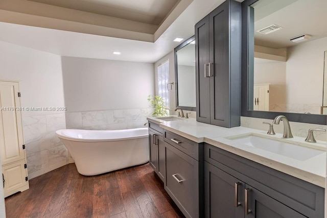 808 Hampton Ct, Weston, FL 33326 - bathroom with tile walls, a freestanding tub, wood finished floors, double vanity, and a wainscoted wall