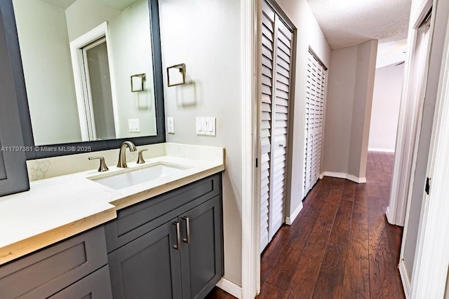 808 Hampton Ct, Weston, FL 33326 - bathroom with hardwood / wood-style flooring, baseboards, vanity, and a textured ceiling