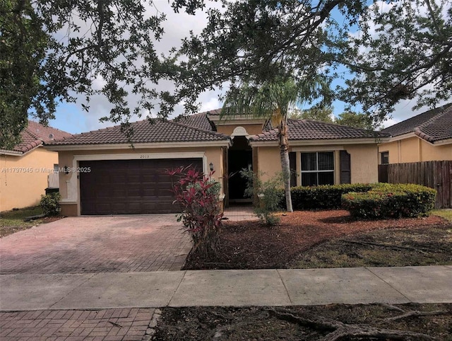 2013 NE 3rd Ct, Homestead, FL 33033 - ranch-style house featuring decorative driveway, fence, a garage, and stucco siding