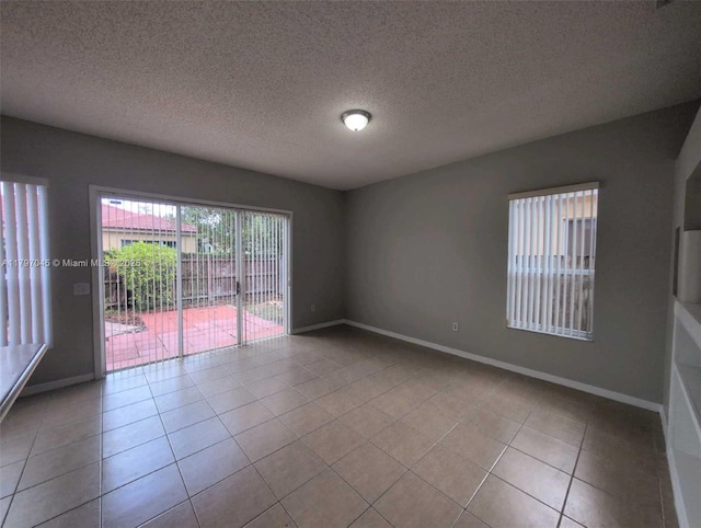 2013 NE 3rd Ct, Homestead, FL 33033 - spare room featuring tile patterned flooring, baseboards, and a textured ceiling
