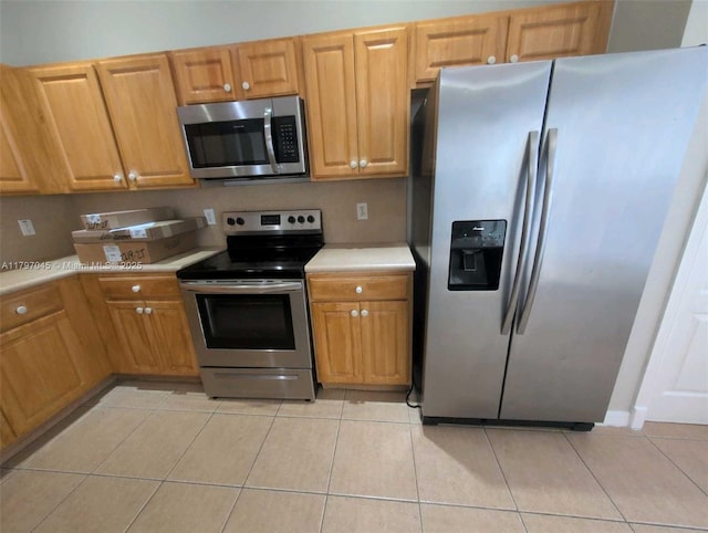 2013 NE 3rd Ct, Homestead, FL 33033 - kitchen featuring stainless steel appliances, light countertops, light tile patterned flooring, and brown cabinets