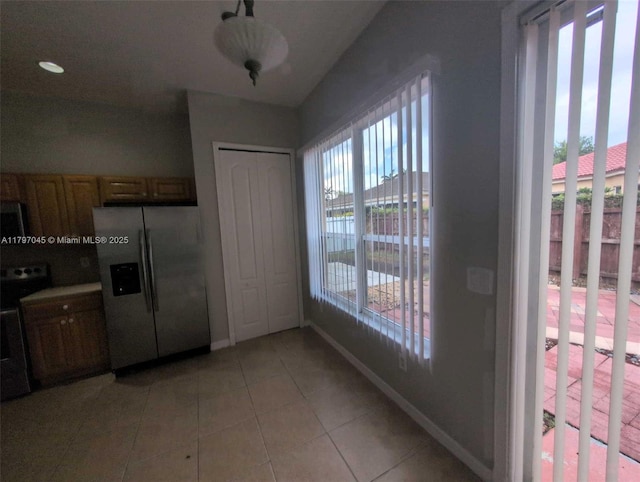 2013 NE 3rd Ct, Homestead, FL 33033 - kitchen featuring stainless steel fridge with ice dispenser, light tile patterned floors, and baseboards