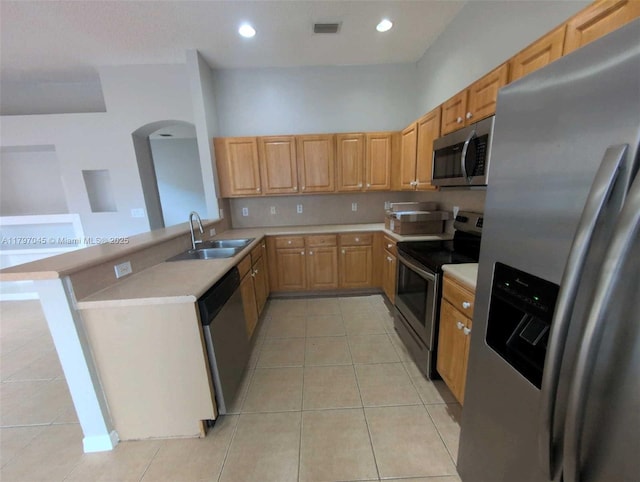 2013 NE 3rd Ct, Homestead, FL 33033 - kitchen with stainless steel appliances, a sink, light countertops, light tile patterned floors, and arched walkways