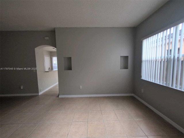 2013 NE 3rd Ct, Homestead, FL 33033 - unfurnished room with plenty of natural light, light tile patterned flooring, and arched walkways