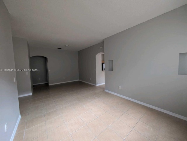 2013 NE 3rd Ct, Homestead, FL 33033 - unfurnished room featuring arched walkways, light tile patterned floors, and baseboards