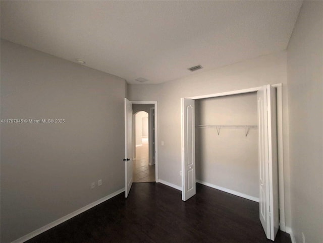 2013 NE 3rd Ct, Homestead, FL 33033 - unfurnished bedroom featuring dark wood-style flooring, baseboards, and a closet