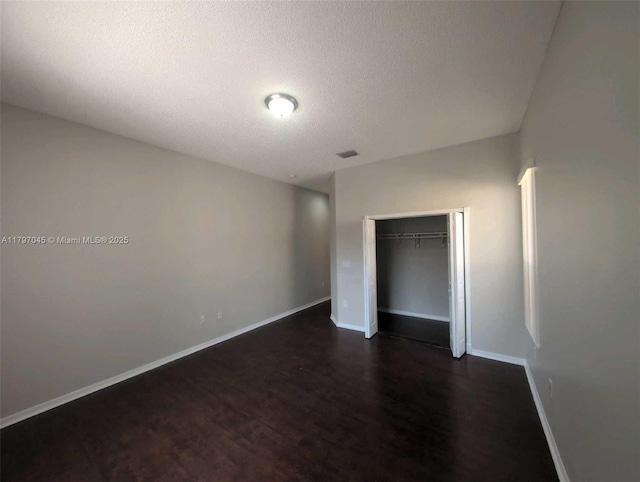 2013 NE 3rd Ct, Homestead, FL 33033 - unfurnished bedroom with dark wood finished floors, a textured ceiling, baseboards, and a closet