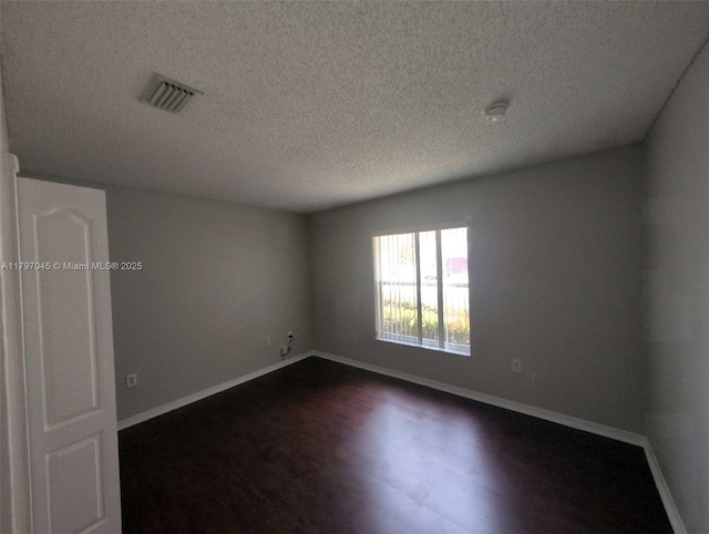 2013 NE 3rd Ct, Homestead, FL 33033 - spare room featuring dark wood-style flooring, a textured ceiling, baseboards, and a smoke detector