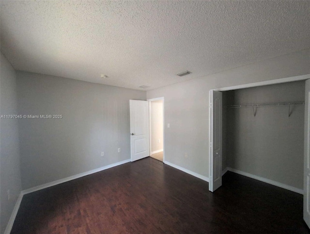 2013 NE 3rd Ct, Homestead, FL 33033 - unfurnished bedroom featuring dark wood finished floors, a textured ceiling, a closet, and baseboards