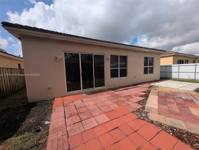 2013 NE 3rd Ct, Homestead, FL 33033 - back of house featuring stucco siding, a fenced backyard, and a patio