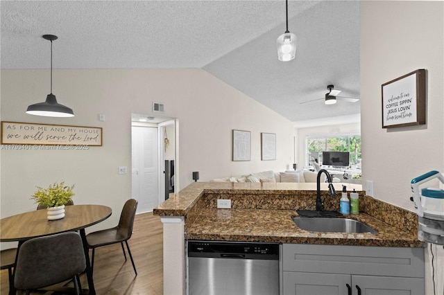 kitchen with dishwasher, a sink, lofted ceiling, light wood-style floors, and open floor plan