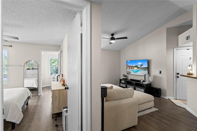 living room with a textured ceiling, lofted ceiling, a ceiling fan, dark wood-style floors, and baseboards