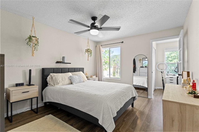 bedroom featuring multiple windows, wood finished floors, a textured ceiling, and ceiling fan