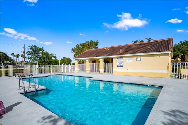 community pool featuring fence and a patio