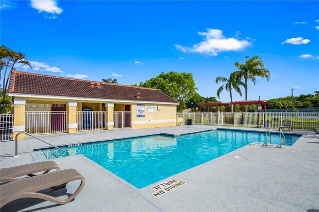 community pool featuring fence, a patio area, and a pergola