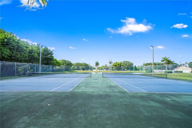 view of tennis court with fence and community basketball court