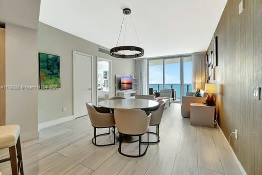 4111 S Ocean Dr Unit 3205, Hollywood, FL 33019 - dining space featuring a chandelier, floor to ceiling windows, light wood finished floors, and baseboards