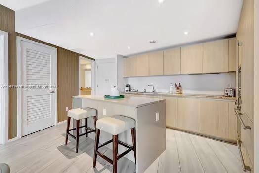 4111 S Ocean Dr Unit 3205, Hollywood, FL 33019 - kitchen featuring a center island, a kitchen bar, light countertops, and light wood-style flooring